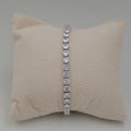 A silver tennis bracelet with round clear stones
